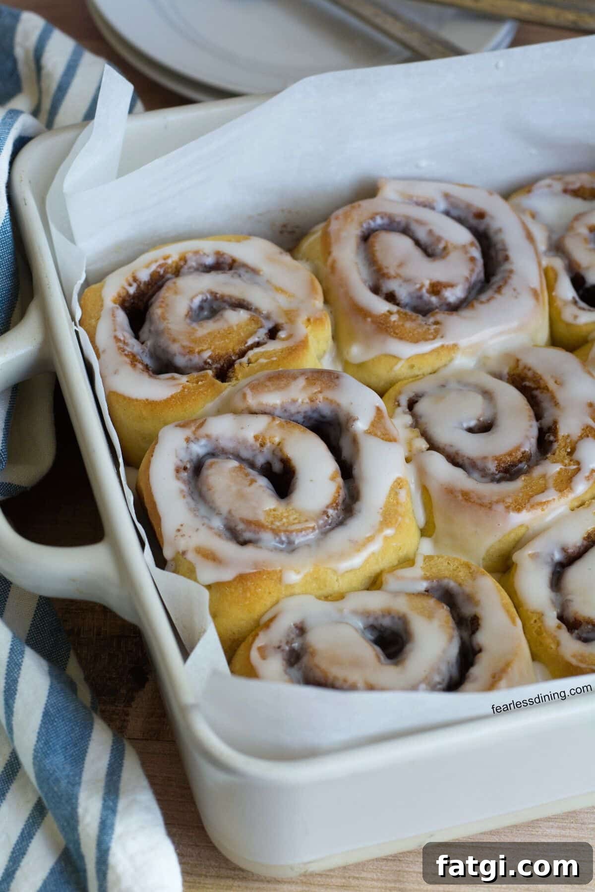 A baking dish filled with iced gluten free sourdough cinnamon rolls.