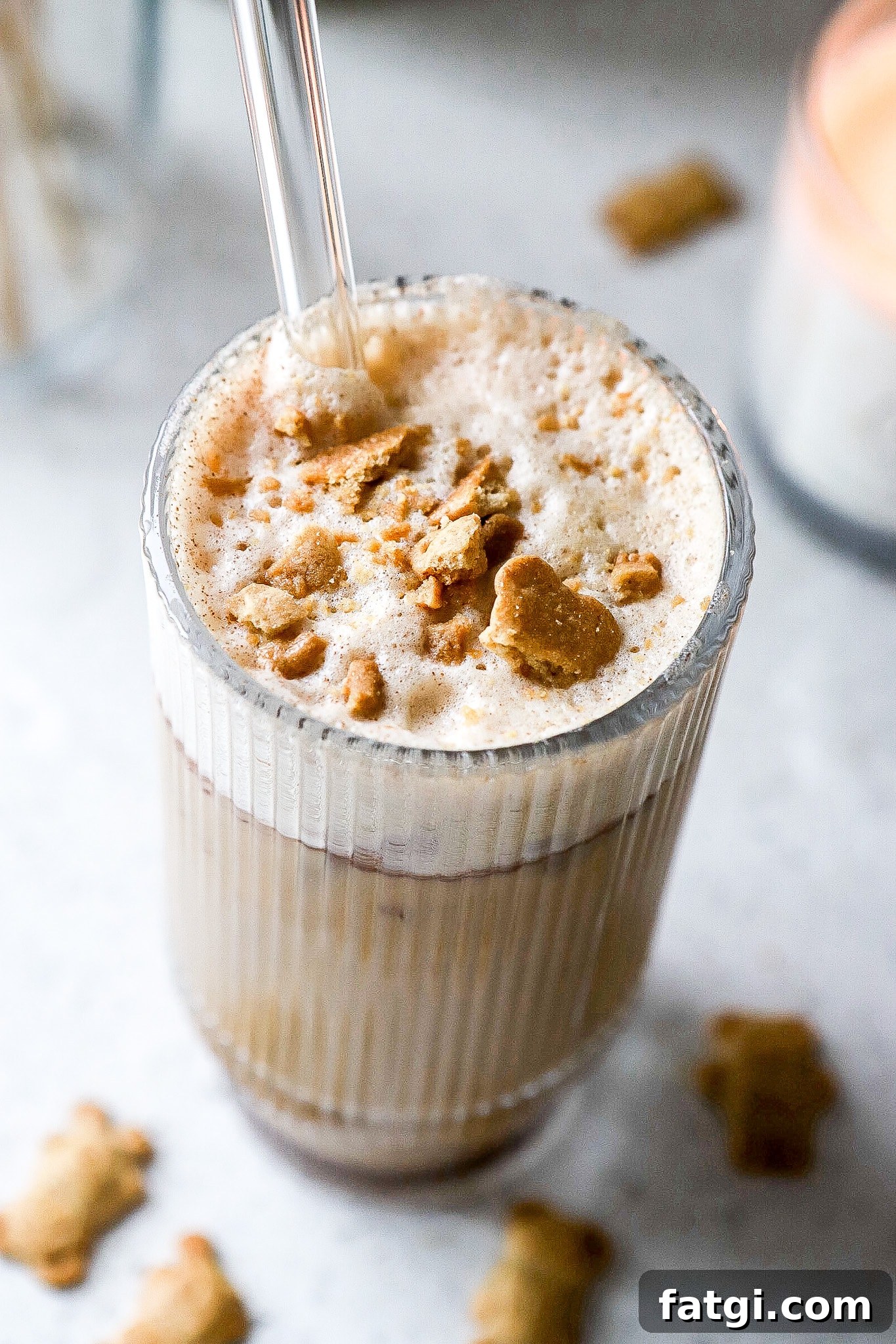 Close up shot of an easy iced latte recipe in glass with glass straw.