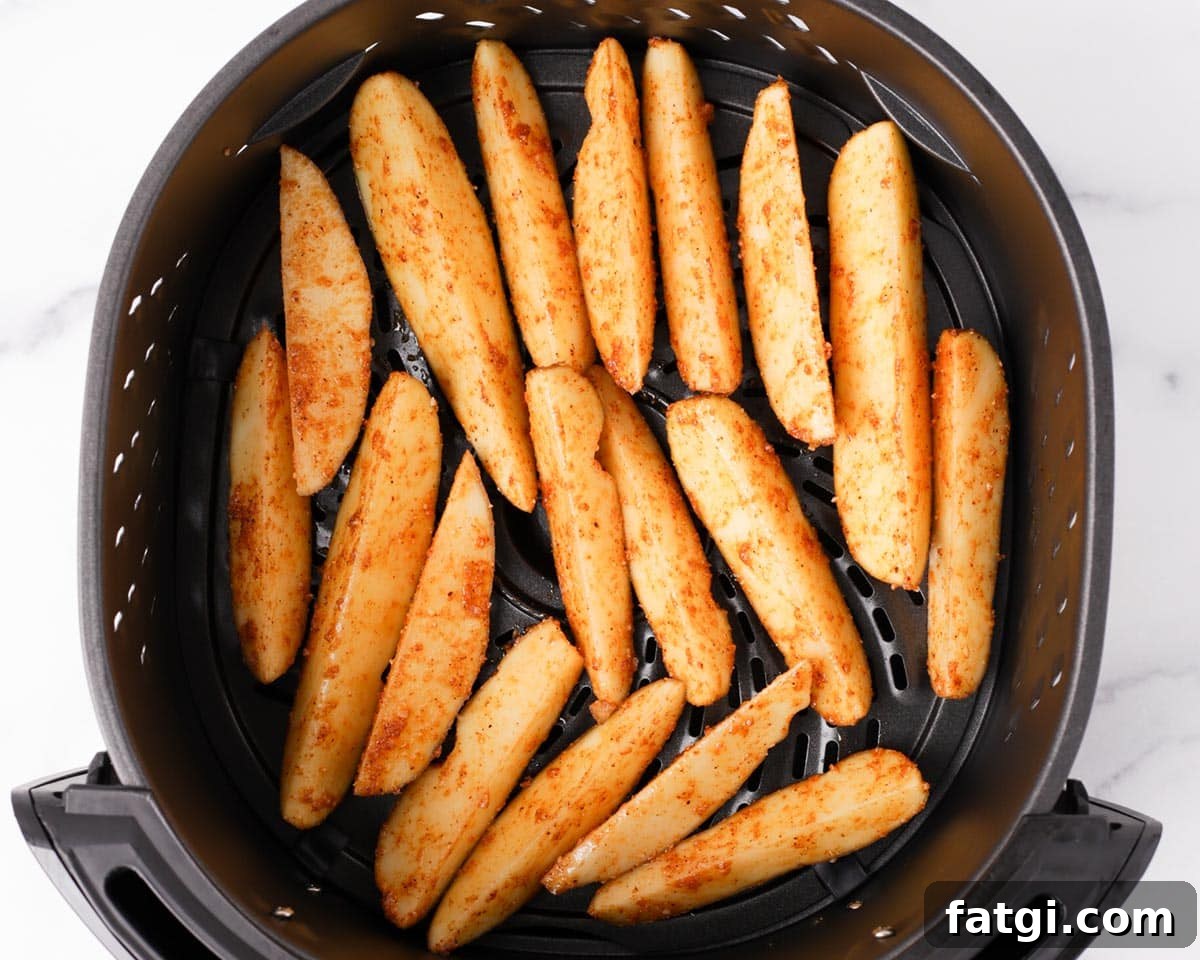 Crispy Air Fryer Potato Wedges 8 Placing potato wedges in air fryer basket.