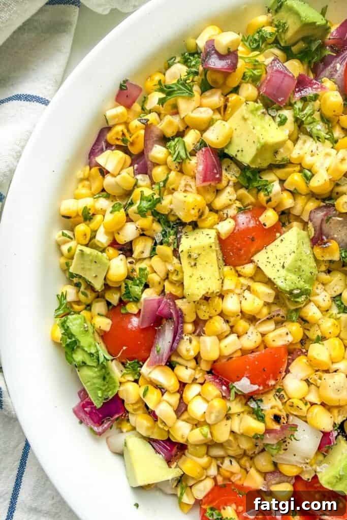 Overhead view of grilled corn salad with avocado and tomatoes.