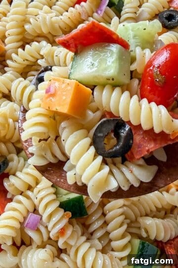 Easy Italian pasta salad made with rotini, vegetables, cheese, and Italian dressing in a large serving bowl.