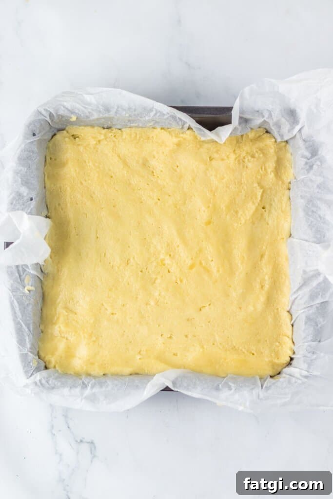 Dough being pressed into a baking dish.