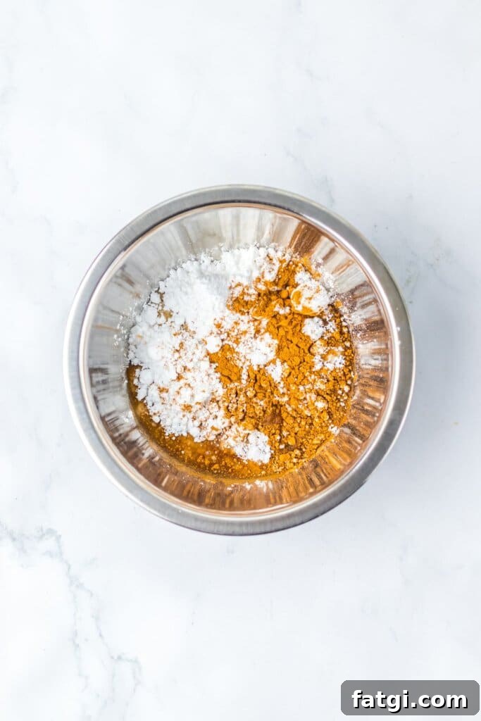 Frosting ingredients being mixed in a stainless steel bowl.