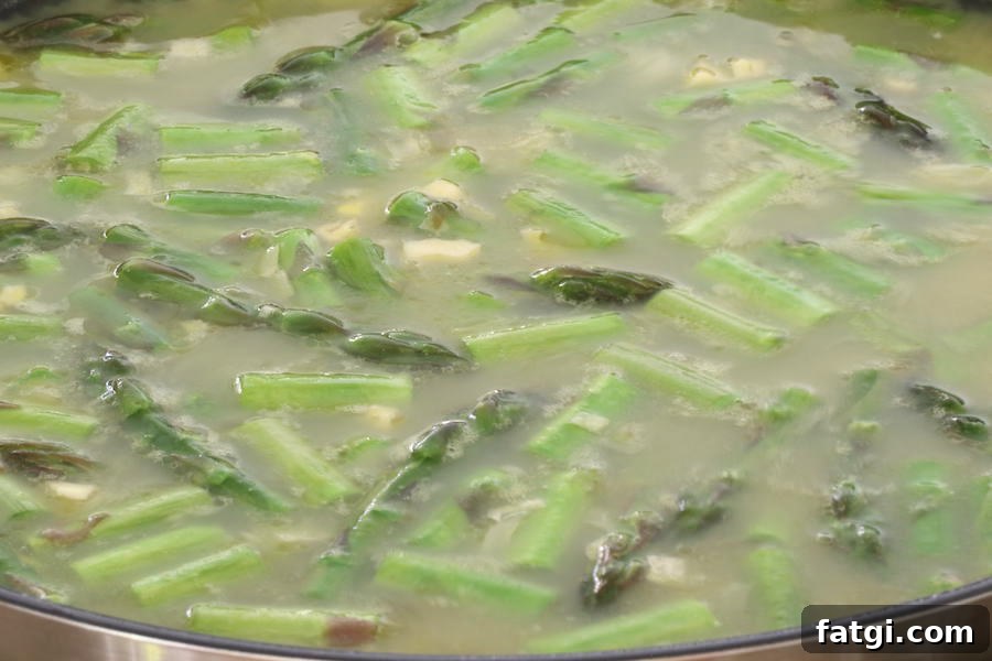 Creamy Vegan Asparagus Risotto Recipe with Garlic and Lemon 4 Asparagus Risotto cooking in pan