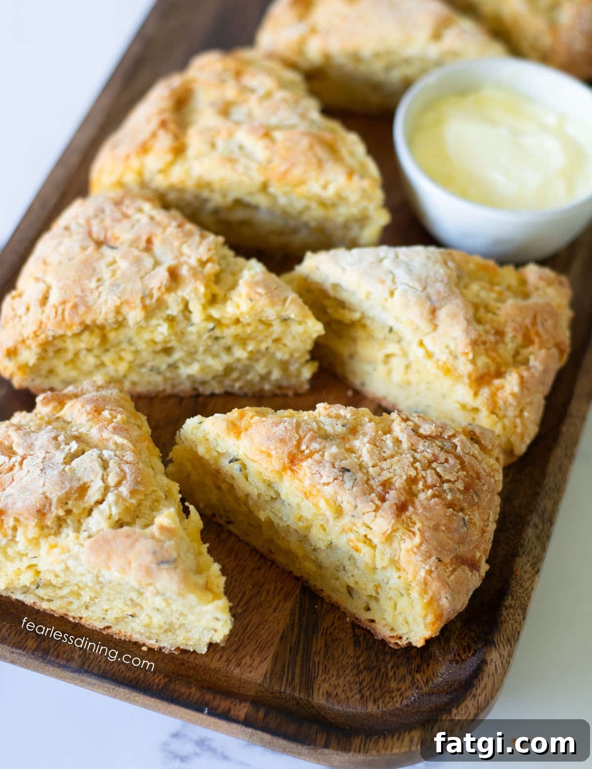 Wedge shaped gluten-free cheese scones on a wooden platter.