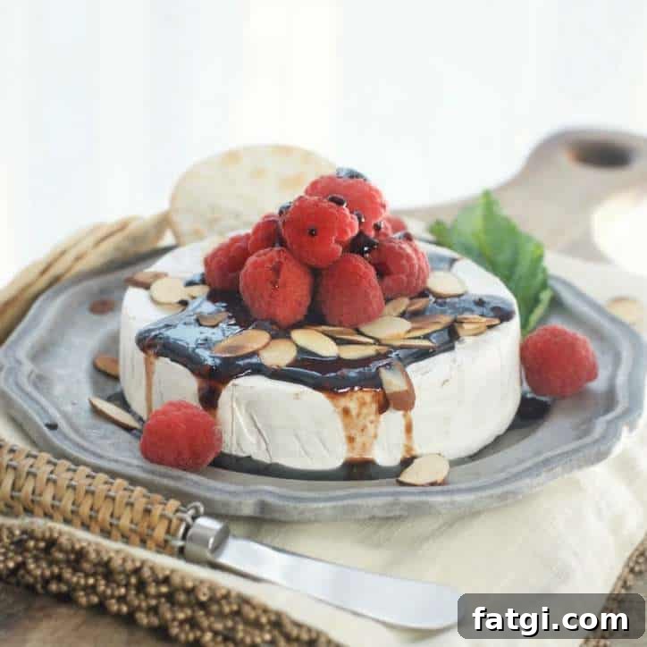 How to Freeze Raspberries for Fresh Flavor All Year 7 A side view of baked brie with sauce and raspberries on top.