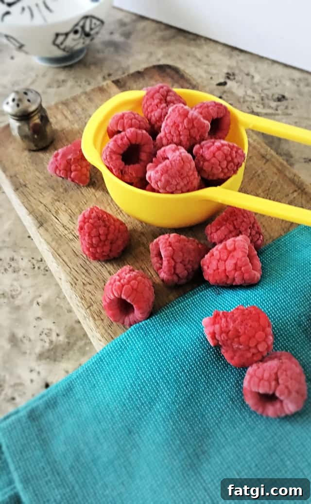 How to Freeze Raspberries for Fresh Flavor All Year 8 yellow half cup measure with raspberries on blue towel