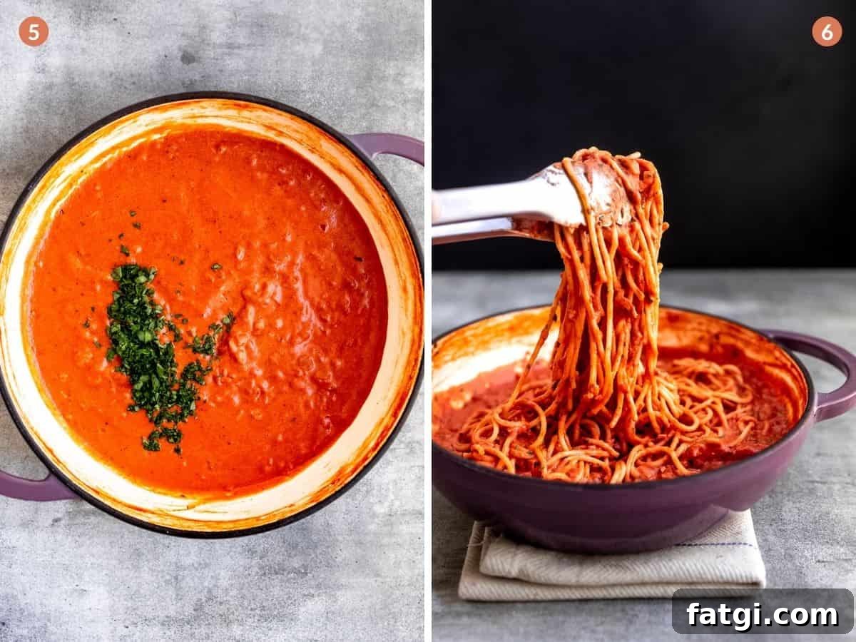Cooked pasta being tossed with rose sauce.