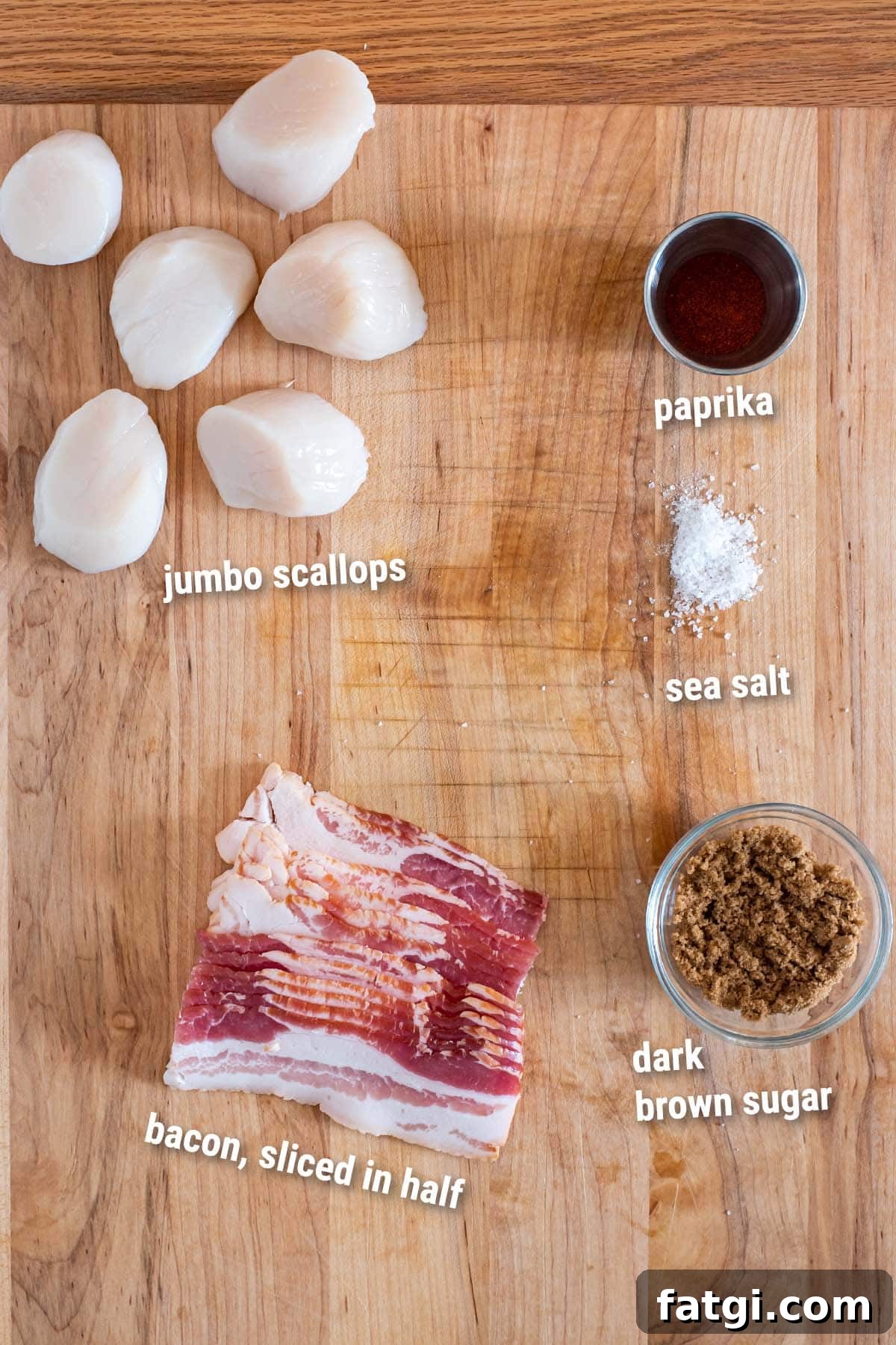 Sweet and Smoky Bacon Wrapped Scallops Recipe 3 Raw ingredients for bacon wrapped scallops on a wooden cutting board.