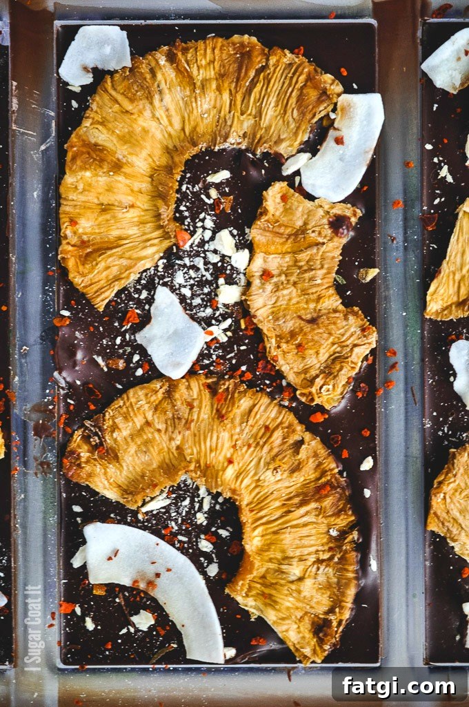 Spicy Pina Colada Dark Chocolate Bar with coconut rum-soaked dehydrated and freeze-dried pineapple, shaved coconut and Aleppo flakes on dark chocolate.