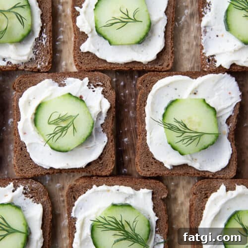 open faced mini cucumber sandwiches on pumpernickel, topped with a dill sprig.