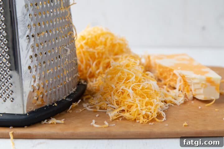 Homemade Cheese Log Recipe 5 shredded colby jack cheese next to a box grater.