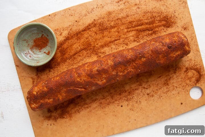 Homemade Cheese Log Recipe 8 cheese roll being rolled in chili powder.