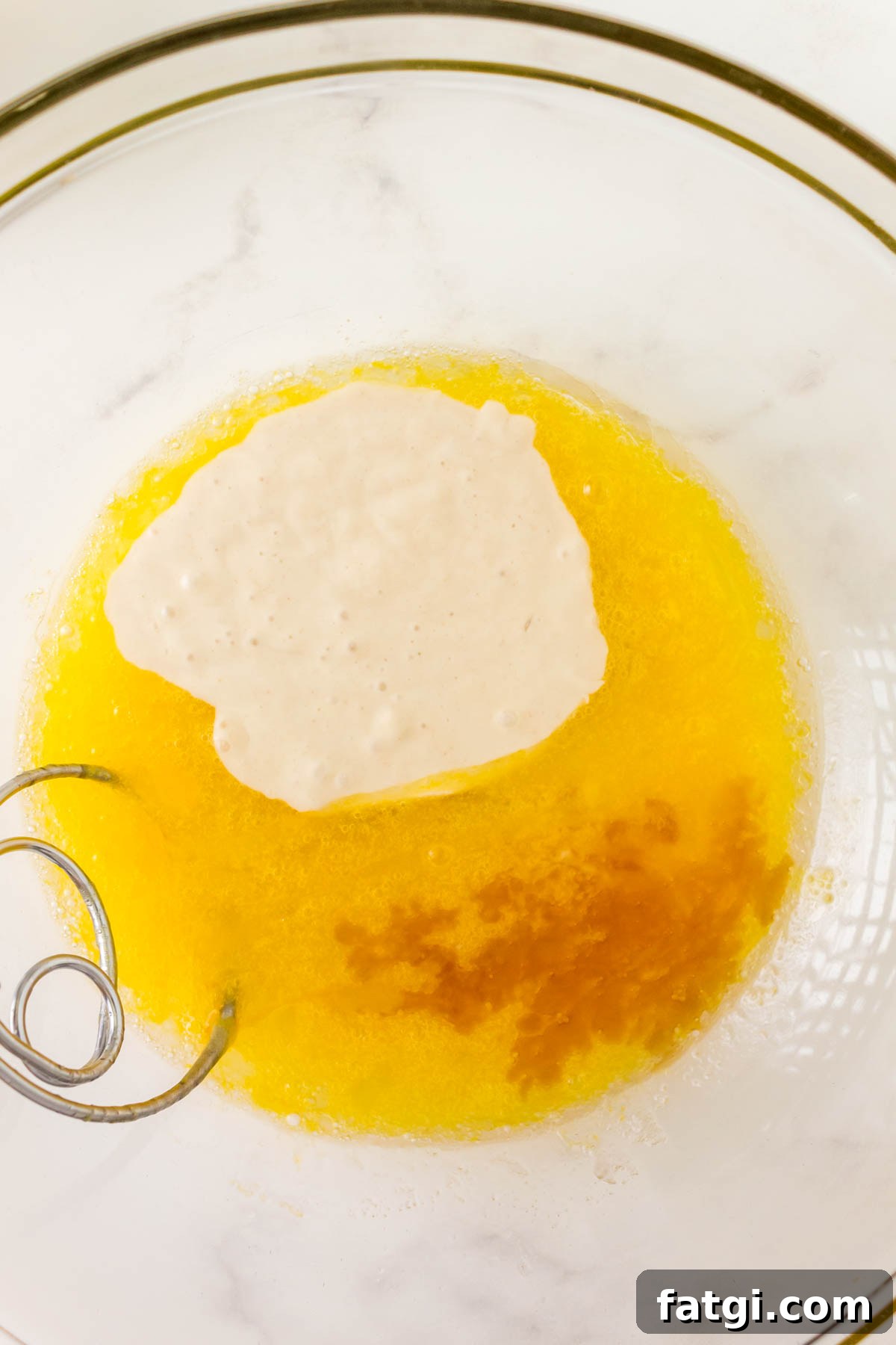 A bowl filled with eggs, sourdough discard, and vanilla extract.