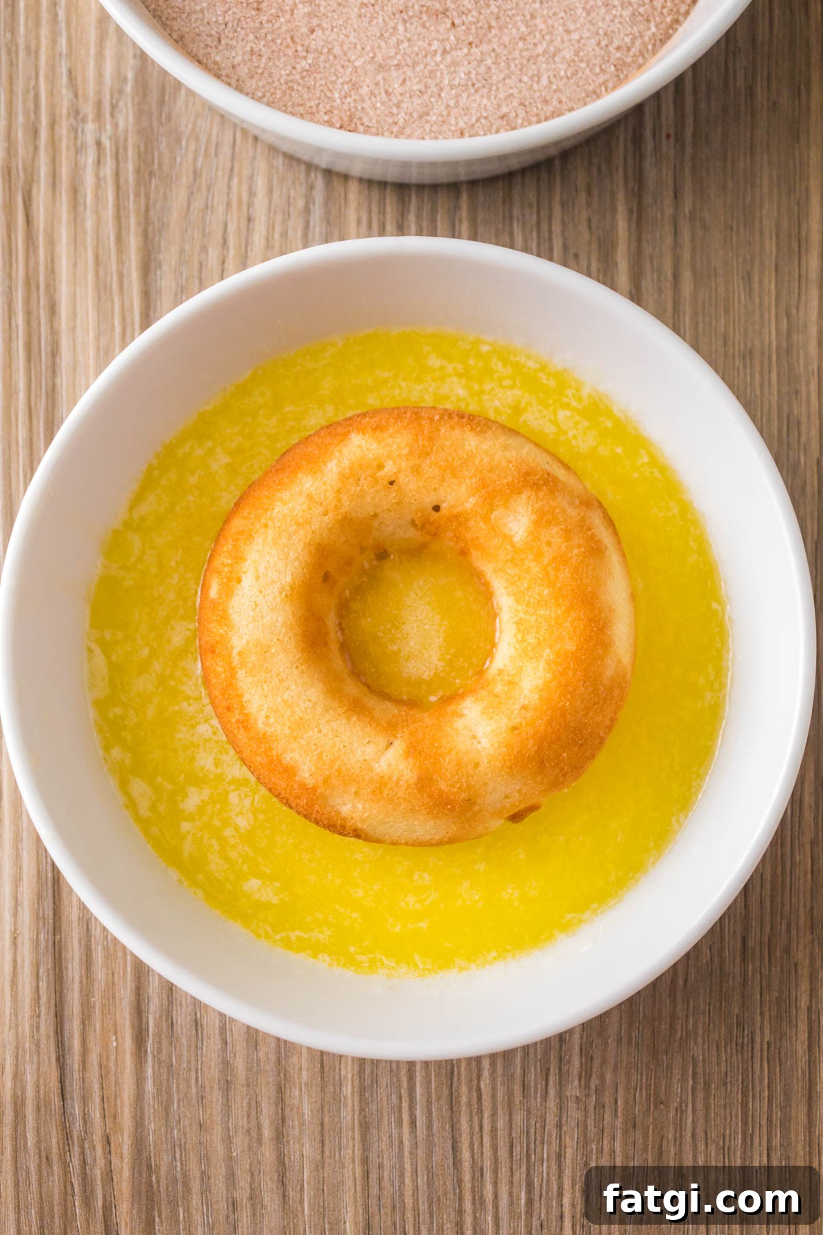 Baked donut sitting in melted butter.