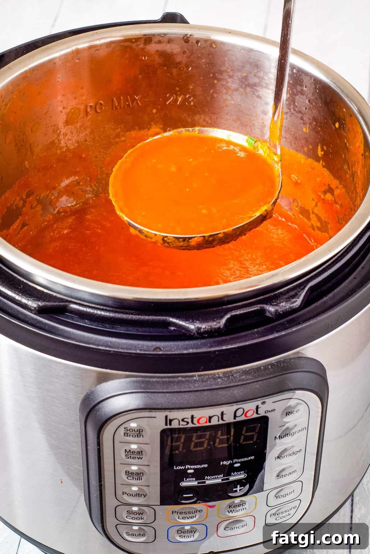 Instant Pot Tomato Soup with Fresh or Canned Tomatoes 9 A close-up view of tomato soup being scooped out of the instant pot.