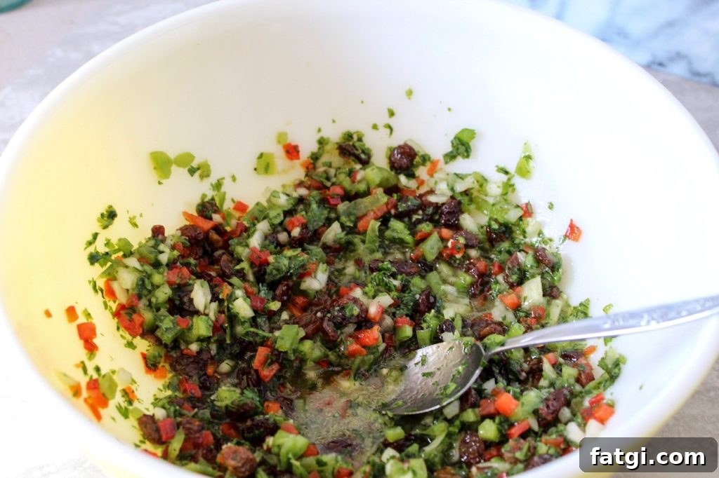 Refreshing Rose Water Quinoa Salad with Citrus & Feta 4 a large bowl with chopped fresh vegetables being mixed with a lemon olive oil vinaigrette