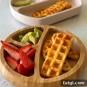 3 ingredient chicken waffles served with ketchup, avocado chunks, and strawberries.