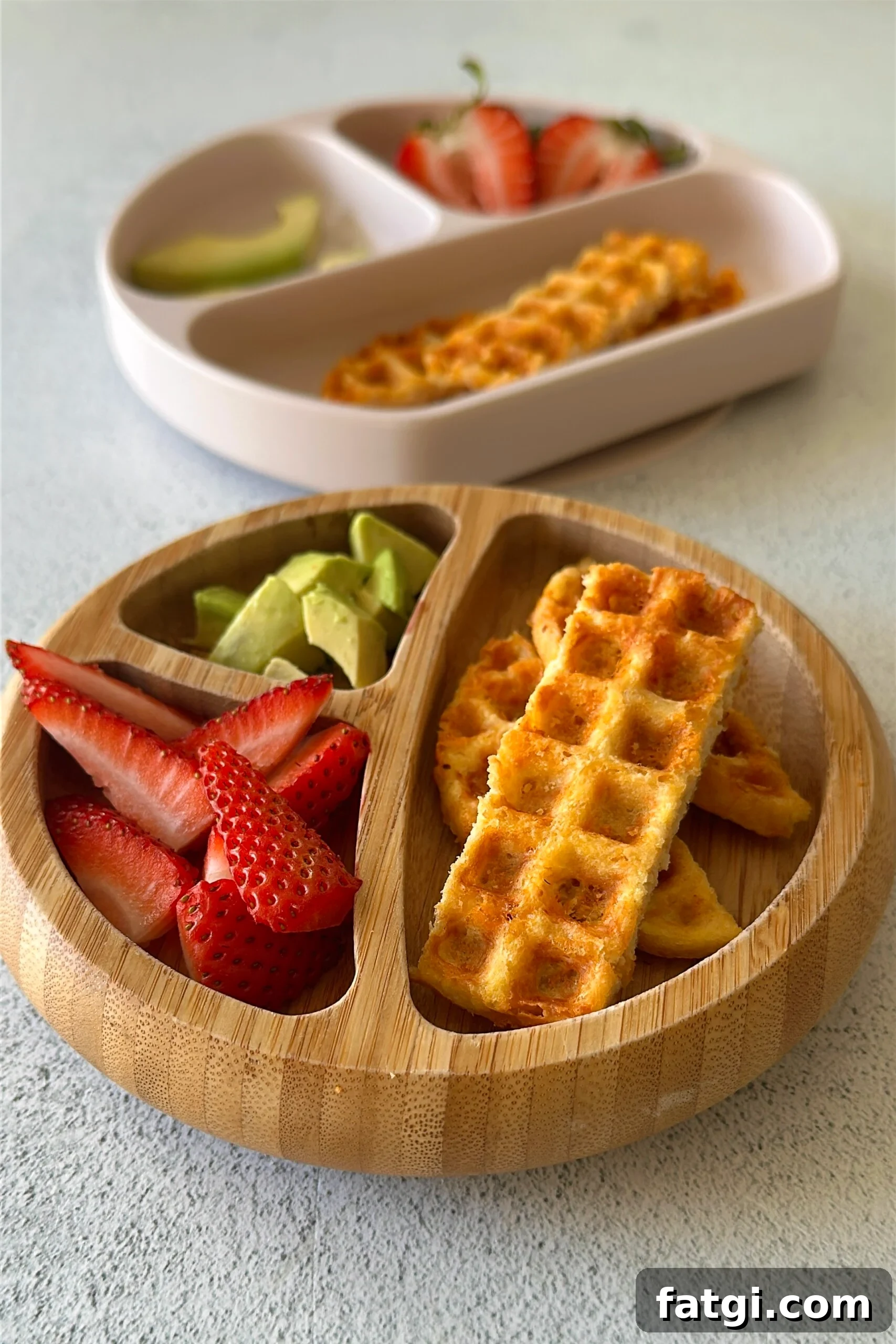 3 ingredient chicken waffles served with ketchup, avocado chunks, and strawberries.