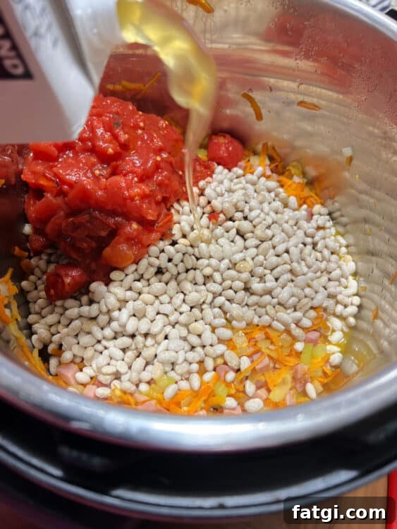Instant Pot Navy Bean and Smoked Ham Soup 5 add beans, tomatoes and chicken broth.