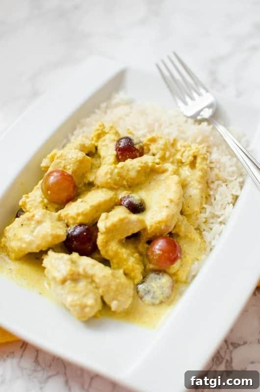 Turkey Curry on a white plate with rice next to a fork