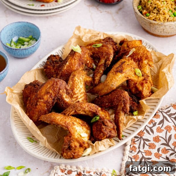 A plate of chinese chicken wings sites on a table for serving.