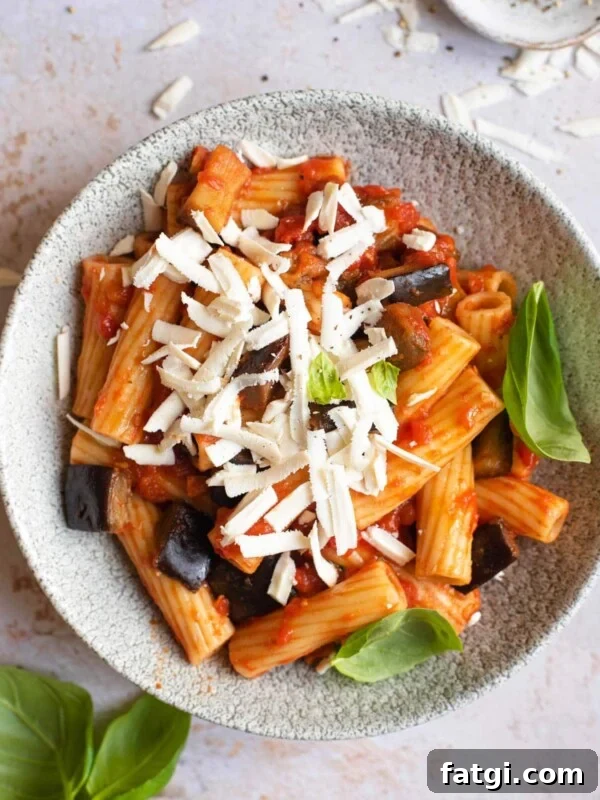 An overhead shot of Pasta alla Norma in a bowl topped with cheese