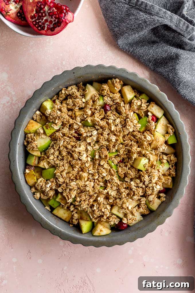 Apple cranberry crisp topped with oat mixture and ready for the oven.