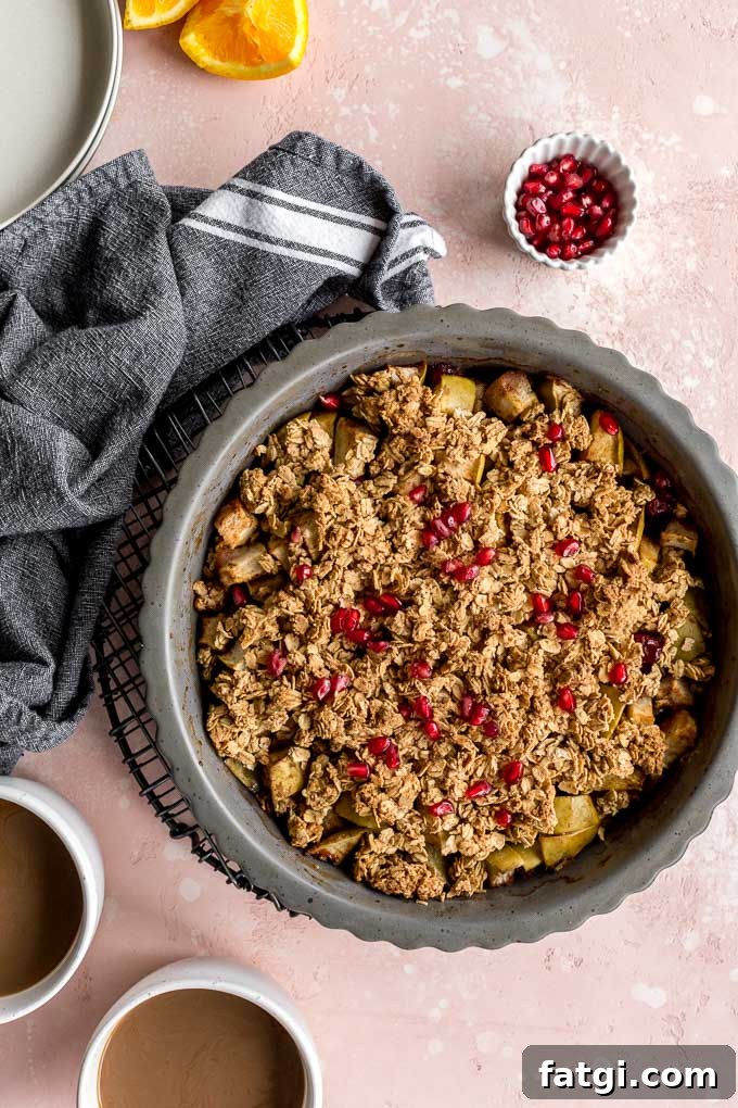 Apple cranberry crisp baked up in a pie plate and cooling on a round wire rack.