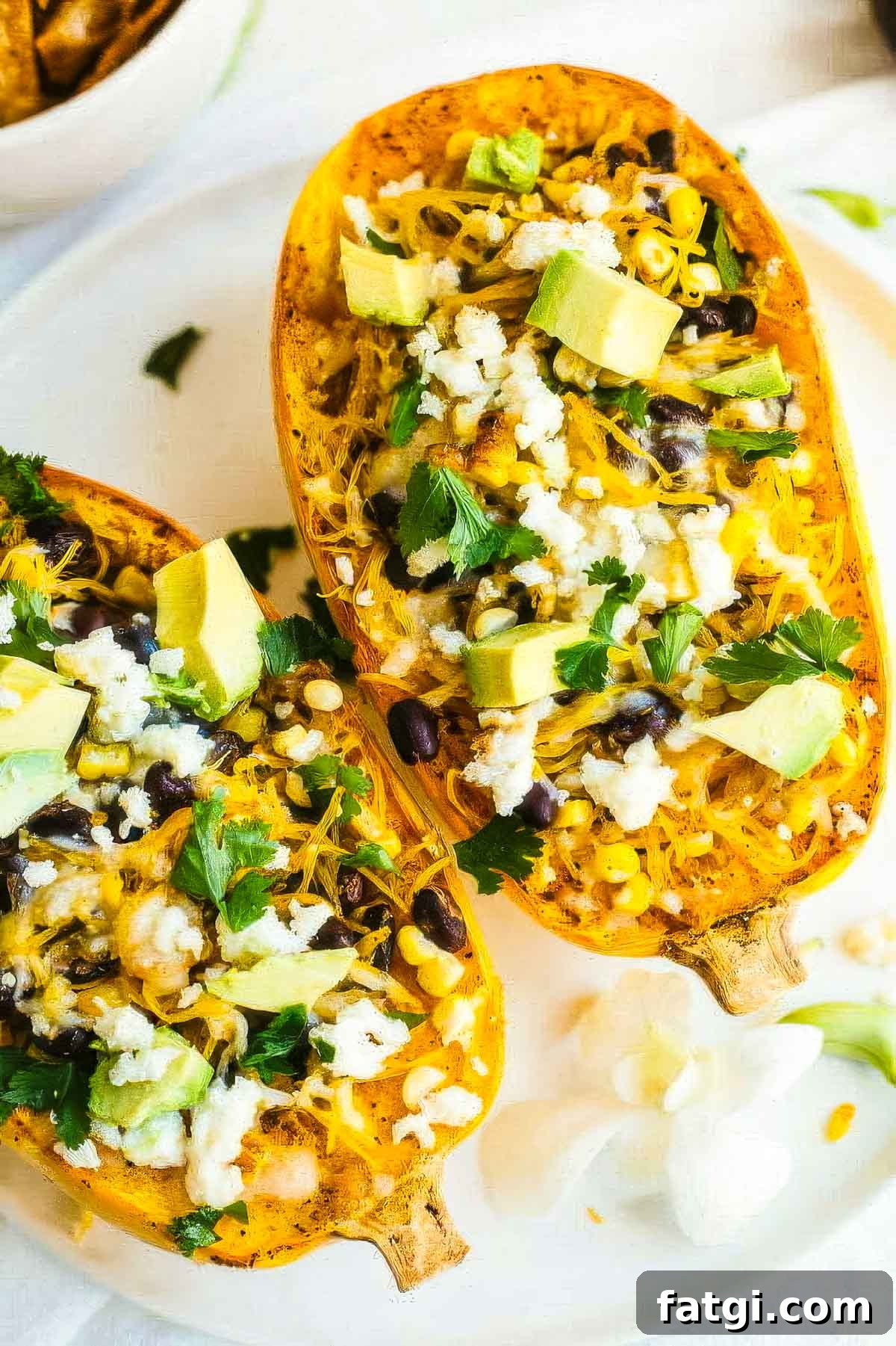 Mexican-Style Spaghetti Squash with Fresh Salsa 3 a closeup of two mexican spaghetti squash on a white plate