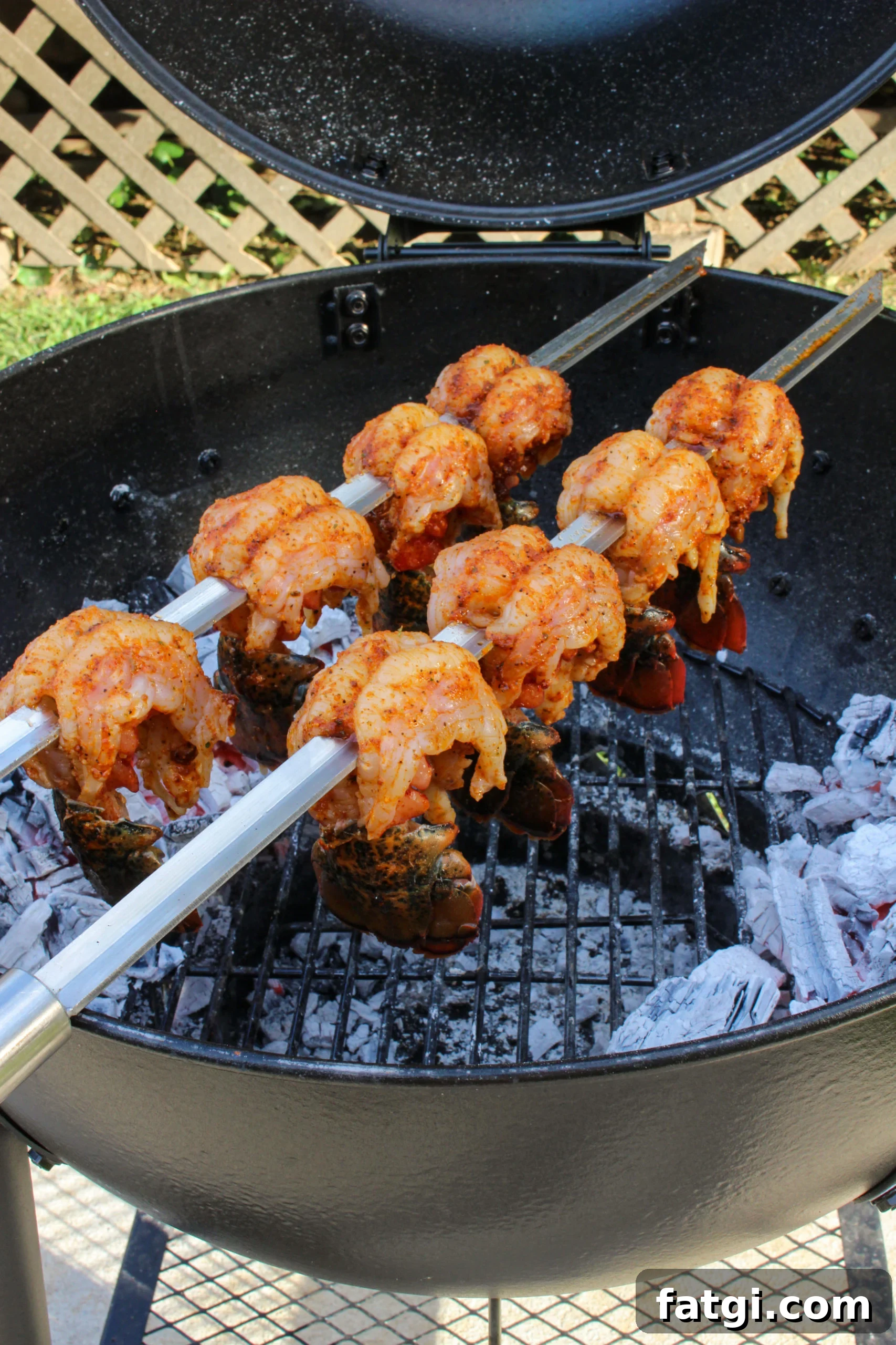 The tails cook over the grill. 