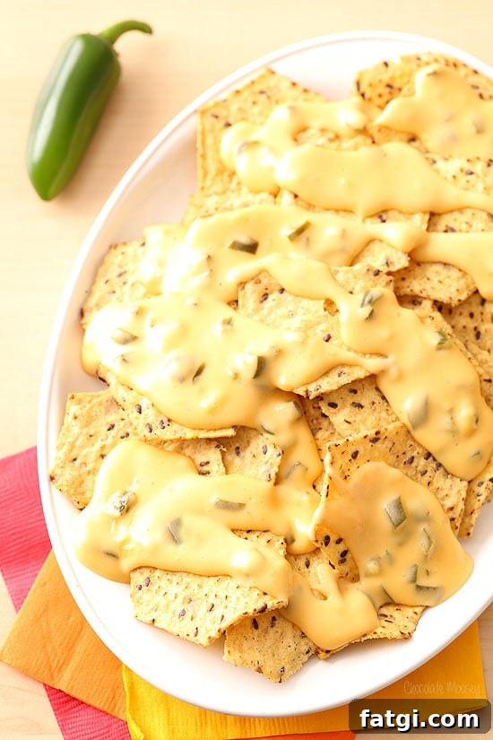 Queso poured over nachos