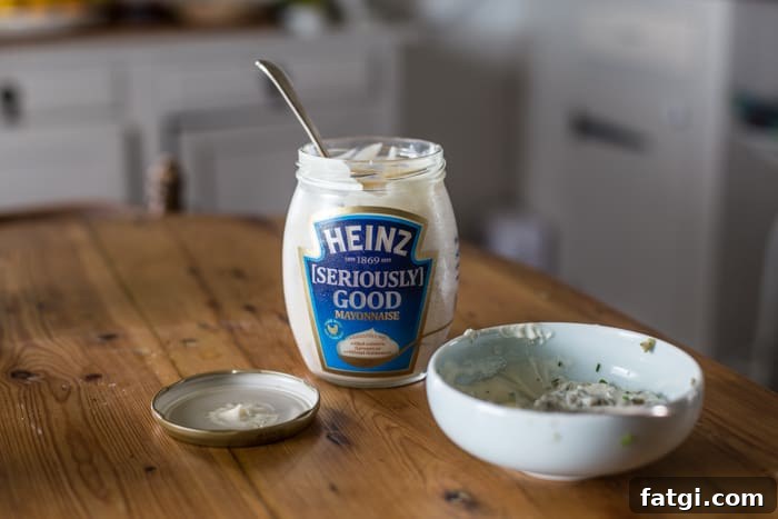 Crispy Fish Balls with Homemade Tartare Sauce 4 Crispy Fish Balls with Easy Tartare Sauce made with Heinz Seriously Good Mayonaise which is beside a bowl of easy tartare sauce on a kitchen table