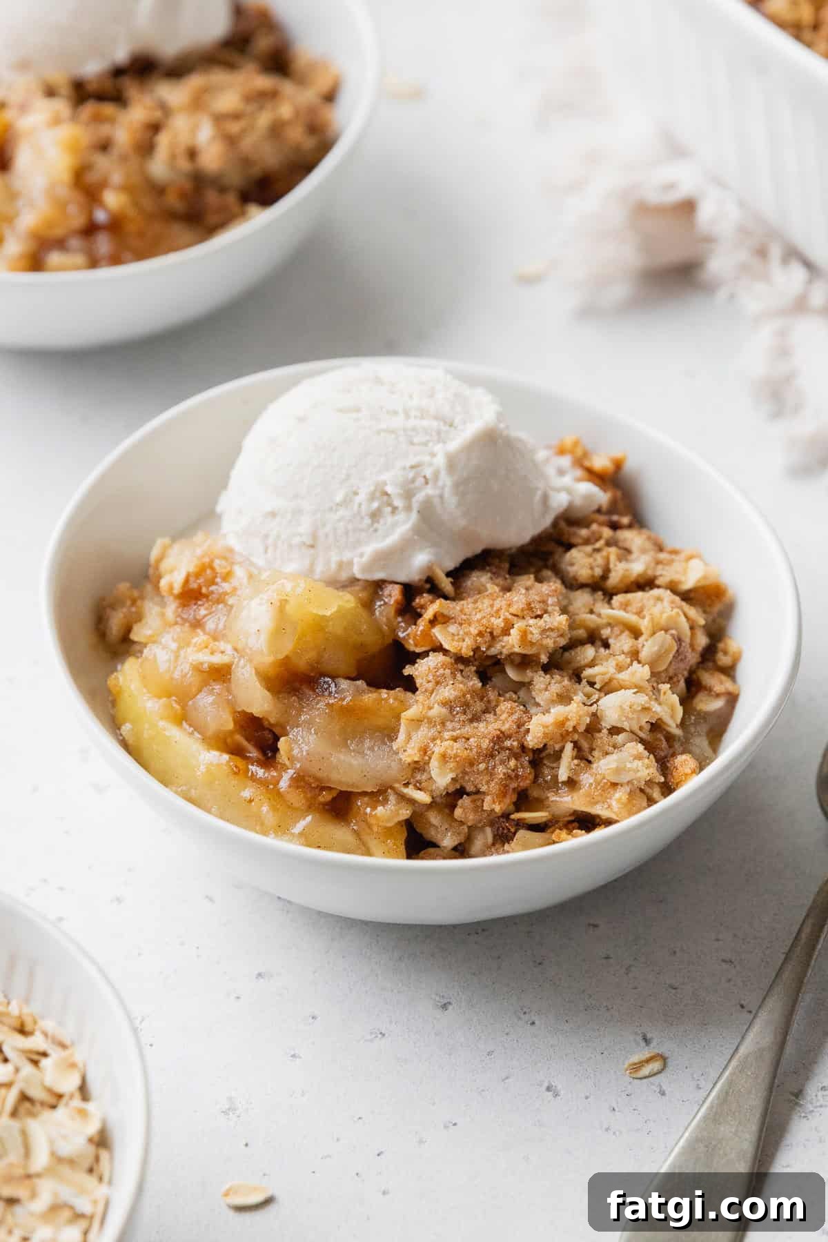 Homemade Gluten-Free Apple Crisp Recipe 10 Apple crisp in a white bowl with a scoop on vanilla ice cream on top.