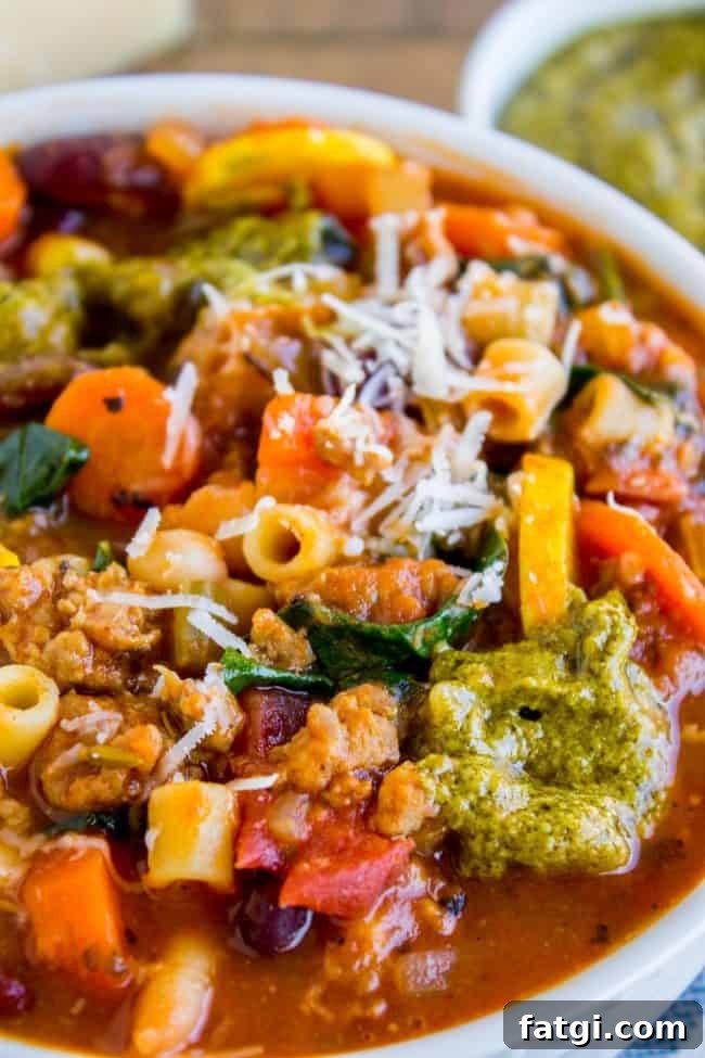 minestrone soup with pesto and sausage in a bowl.