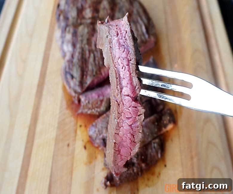 medium rare slice of flat iron steak on a fork
