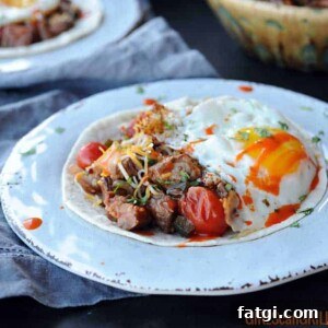 white plate with tortilla, beef, salsa and egg
