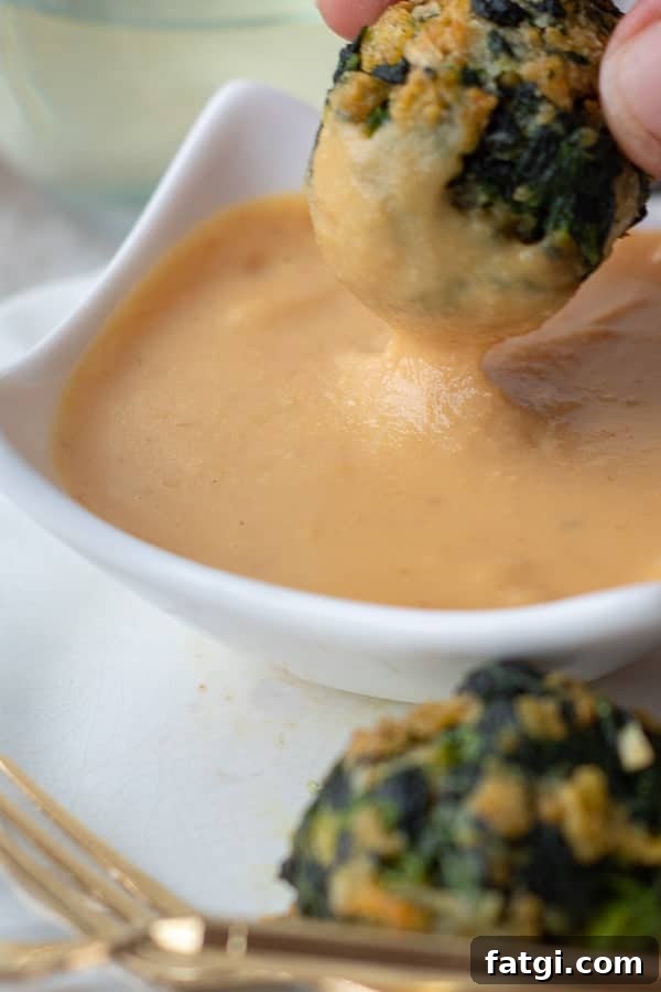 a spinach balls being dipped into mustard dipping sauce