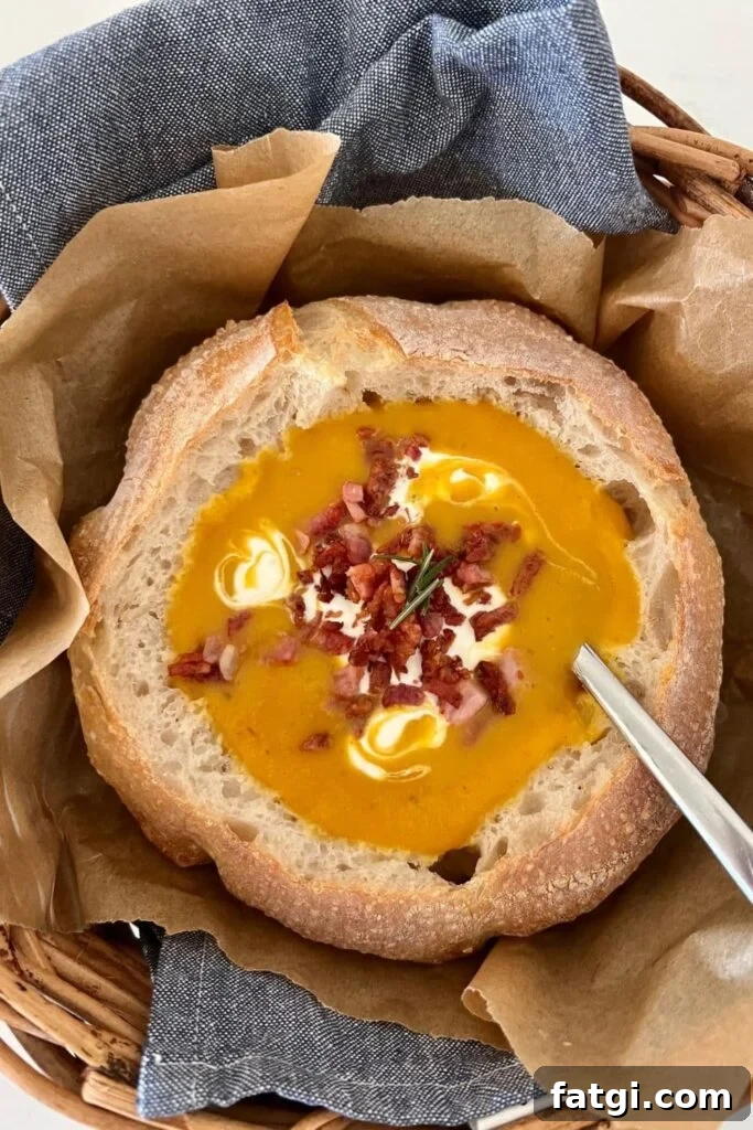 Sourdough Bread Bowl filled with pumpkin soup that has been topped with sour cream and bacon.