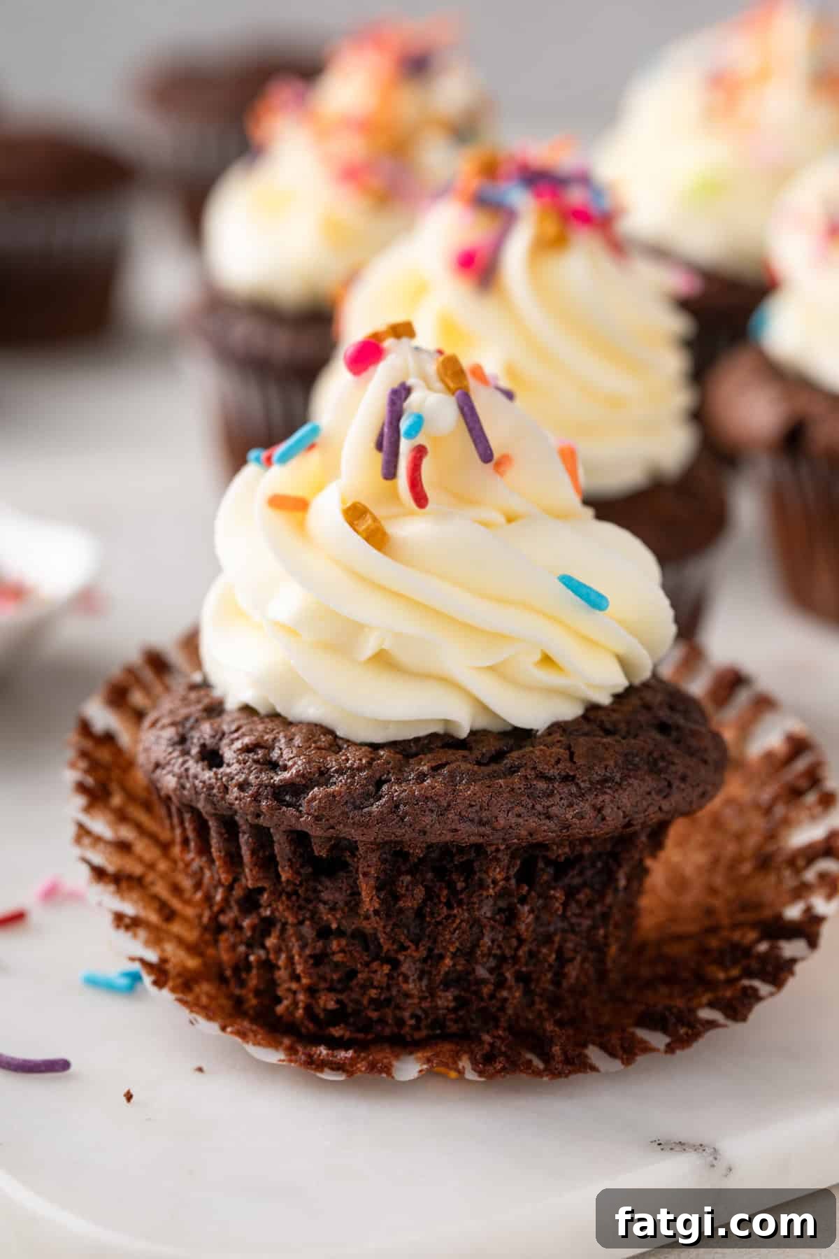 How to Transform Boxed Cake Mix into Gourmet Cakes 3 Chocolate cupcake made with doctored cake mix unwrapped on a countertop.