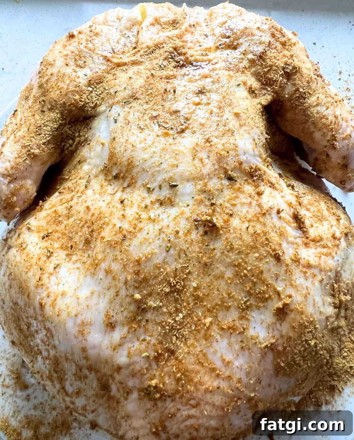 Seasoned whole chicken ready for air fryer.
