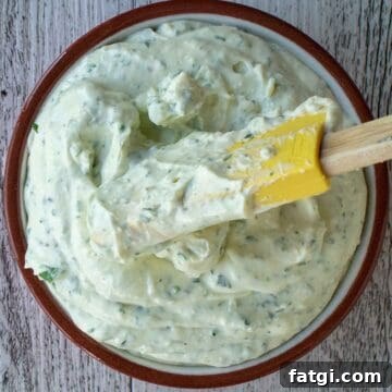 Creamy Homemade Garlic and Herb Cheese Spread Recipe 7 Creamy dip with green flecks in a bowl viewed from above.