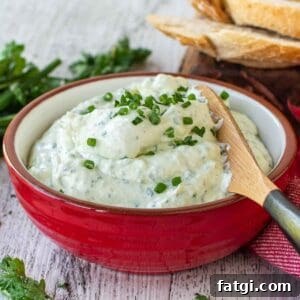 Creamy Homemade Garlic and Herb Cheese Spread Recipe 10 Garlic and herb cheese spread in a red bowl, garnished with chopped chives.
