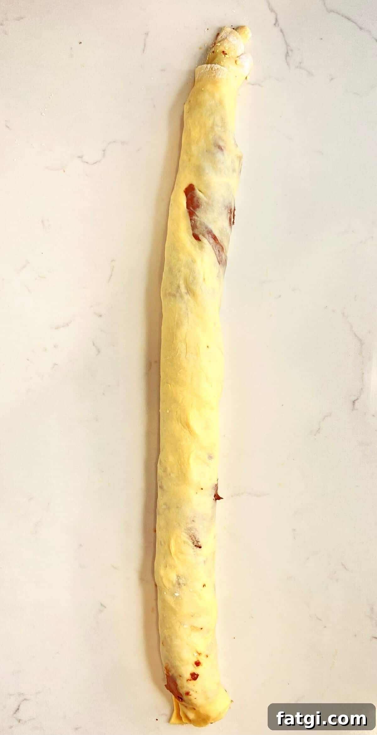 Rolling the dough and filling into a log shape.