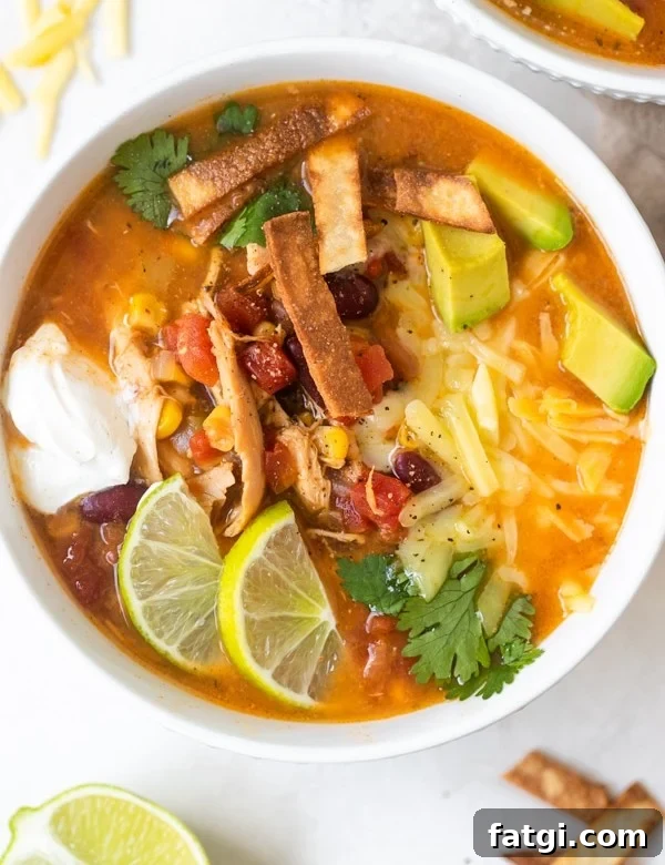taco soup in a white bowl with toppings on top