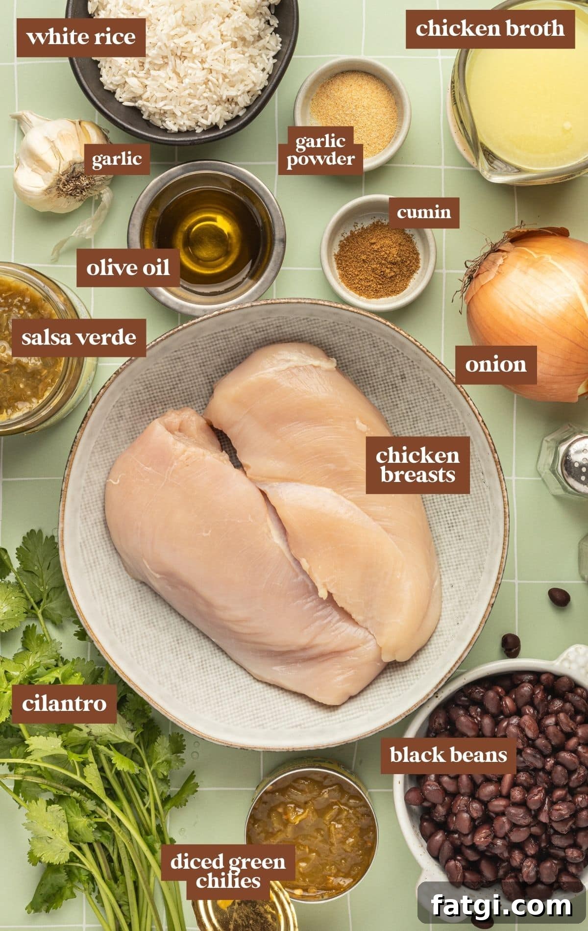 Ingredients in bowls with text labels on them. Includes white rice, chicken brother, garlic powder, garlic, cumin, olive oil, onion, salsa verde, raw chicken, cilantro, green chilies, and black beans.