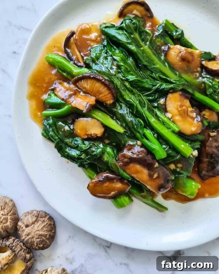 Close up of Chinese broccoli with shiitake mushrooms on top left corner
