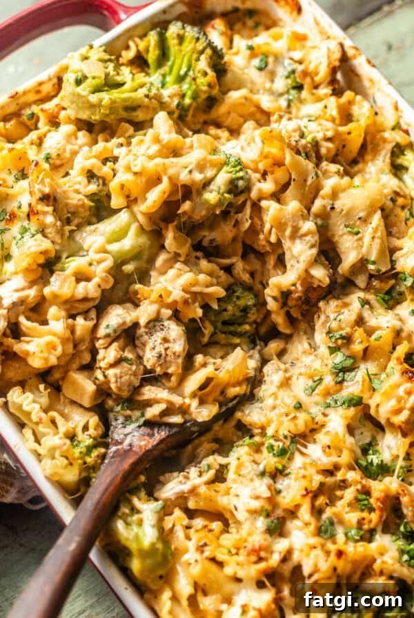 overhead photo of baked chicken and broccoli alfredo in a baking dish with a spoon.