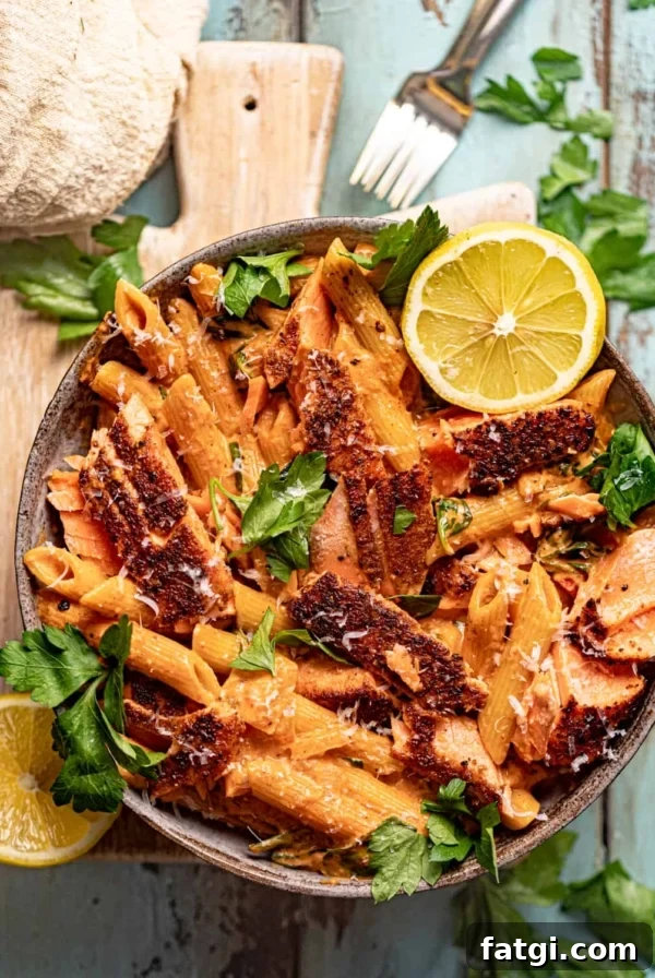 cajun salmon pasta in a bowl on top of a serving board.