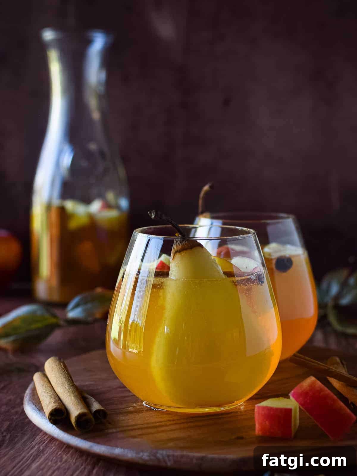 Apple and pear sangria in a glass on a wooden board.